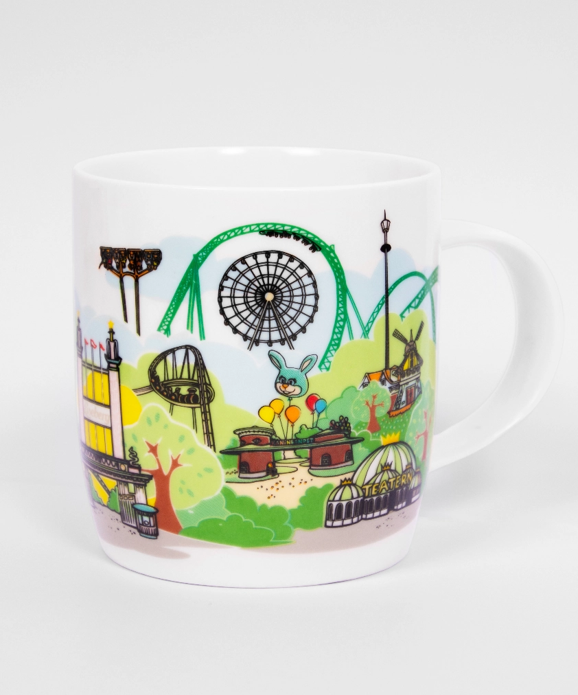 En vit mugg dekorerad med en f&auml;rgstark tecknad illustration av n&ouml;jesparken Lisebergs skyline, som visar berg- och dalbanor, pariserhjulet och Lisebergskaninen.