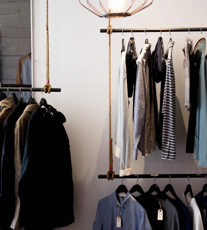 Herr- och damtröjor som hänger på en klädhängare i en butik